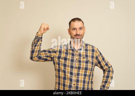 Homme brunette confiant, debout uni avec des vies noires mouvement d'importance, montrant le poing levé et regardant la caméra, protestant et étant un activiste Banque D'Images