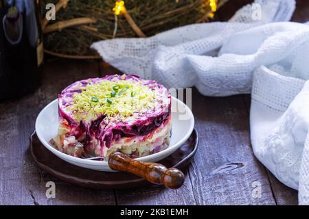 Harengs vêtus, salade soviétique radieuse de hareng et de légumes dans une décoration du nouvel an. Banque D'Images