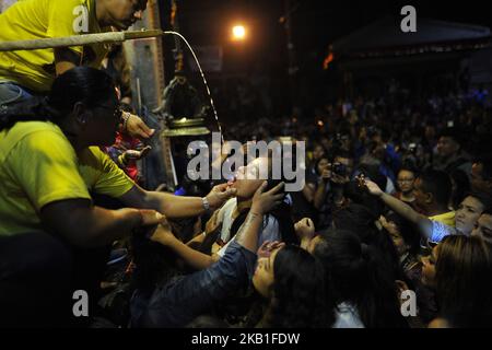 Les jeunes femmes et femmes népalaises boit du riz Saint la bière coule de la bouche l'énorme masque de l'idole Swet Bharab pendant le festival Indra Jatra célébré à la place Basantapur Durbar, Katmandou, Népal mercredi, 26 septembre 2018. Indra Jatra est la célébration du jour de Dieu Indra, le roi du ciel. Le festival Indra Jatra est célébré à Basantapur Durbar Square, Katmandou, Népal. Indra Jatra est l'un des festivals importants du Népal célébrant la fin de la mousson. Le plus grand festival où Kumari se présente dans le public est à Indra Jatra. Le lendemain, le char de Kumari, Bhaira Banque D'Images