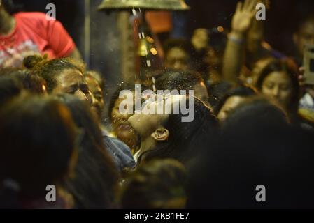 Les jeunes femmes et femmes népalaises boit du riz Saint la bière coule de la bouche l'énorme masque de l'idole Swet Bharab pendant le festival Indra Jatra célébré à la place Basantapur Durbar, Katmandou, Népal mercredi, 26 septembre 2018. Indra Jatra est la célébration du jour de Dieu Indra, le roi du ciel. Le festival Indra Jatra est célébré à Basantapur Durbar Square, Katmandou, Népal. Indra Jatra est l'un des festivals importants du Népal célébrant la fin de la mousson. Le plus grand festival où Kumari se présente dans le public est à Indra Jatra. Le lendemain, le char de Kumari, Bhaira Banque D'Images