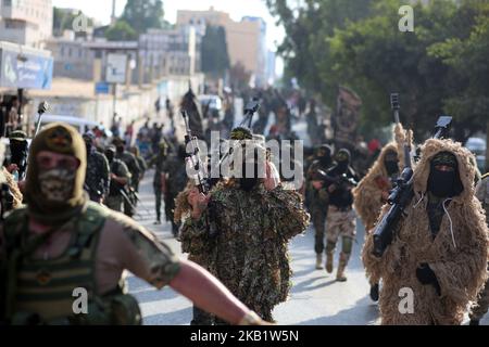 Des membres palestiniens masqués des Brigades Al-Quds, l'aile militaire du groupe du Jihad islamique, marchent avec leurs armes pour montrer leur loyauté envers le leader nouvellement élu du mouvement palestinien soutenu par l'Iran, Ziad al-Nakhala, lors d'un rassemblement dans les rues de Gaza, le jeudi 4 octobre 2018. (Photo de Majdi Fathi/NurPhoto) Banque D'Images