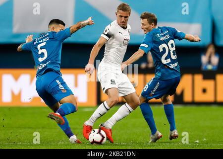 Leandro Paredes (L) et Yevgeni Chernov (R) du FC Zenit Saint-Pétersbourg rivalisent pour le bal avec Yury Gazinsky du FC Krasnodar lors du match de la première Ligue russe entre le FC Zenit Saint-Pétersbourg et le FC Krasnodar sur 7 octobre 2018 au stade de Saint-Pétersbourg à Saint-Pétersbourg, en Russie. (Photo de Mike Kireev/NurPhoto) Banque D'Images