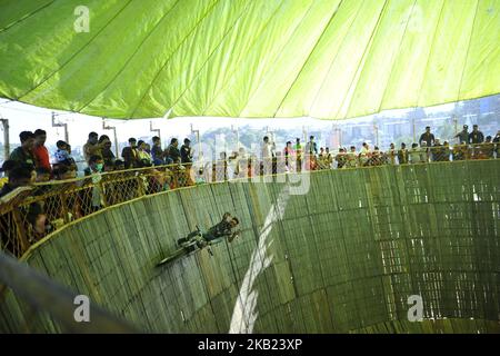 Un cascadeur de moto fait une moto à l'intérieur du puits de la mort lors d'une foire à Katmandou le dimanche, 14 octobre 2018. (Photo de Narayan Maharajan/NurPhoto) Banque D'Images