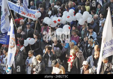 Les Ukrainiens tiennent des pancartes et des drapeaux lorsqu'ils assistent à un rassemblement organisé par la Fédération des syndicats d'Ukraine, devant le bâtiment du Cabinet des ministres, à Kiev, en Ukraine, le 17 octobre 2018. Des milliers d'Ukrainiens ont participé à un rassemblement consacré à la Journée internationale pour l'élimination de la pauvreté, exigeant une augmentation du salaire minimum, des tarifs bas du logement et des services publics, et assurant le développement de la production domestique pour créer des lieux de travail avec des salaires appropriés. (Photo de NurPhoto) Banque D'Images