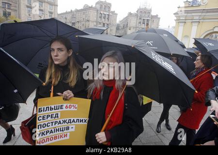 Les Ukrainiens portent des affiches et des parapluies noirs lors de leur marche silencieuse contre la traite des êtres humains appelée «Marche pour la liberté», dans le centre-ville de Kiev, en Ukraine, le 20 octobre 2018. La marche consacrée à la Journée européenne de lutte contre la traite, qui a eu lieu le 18 octobre, visait à sensibiliser le public au problème de la traite des êtres humains et de l'esclavage. (Photo par STR/NurPhoto) Banque D'Images