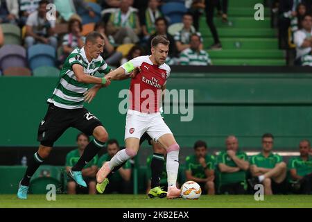 Aaron Ramsey, milieu de terrain d'Arsenal du pays de Galles (R ), rivalise avec le milieu de terrain de Sporting Radosav Petrovic, de Serbie, lors du match de football de l'UEFA Europa League Group E Sporting CP vs Arsenal FC au stade José Alvalade de Lisbonne, Portugal, on 25 octobre 2018. ( Photo par Pedro Fiúza/NurPhoto) Banque D'Images