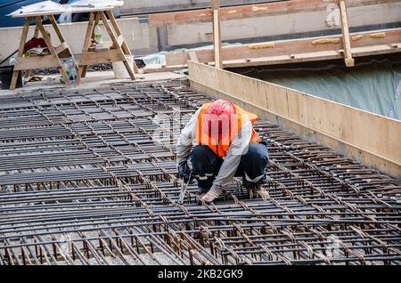 Les ouvriers spécialisés dans la construction de treillis métallique utilisent du fer, du treillis métallique, des barres d'acier (appelées barres d'armature) ou des câbles pour renforcer le béton Banque D'Images