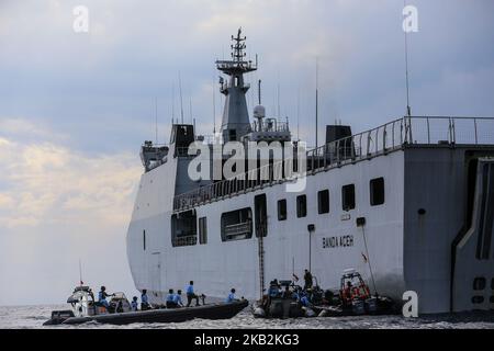 Une équipe de sauvetage passe près du navire de la marine KRI Banda Aceh à l'emplacement de l'écrasement du vol JT610 de l'Air du lion au large de la côte nord de la régence de Karawang, province de Java Ouest, Indonésie, mardi, 30 octobre, 2018. Les sauveteurs ont récupéré des restes humains et des objets personnels dans l'épave, les 189 passagers et l'équipage craignaient tous la mort. Le vol 610 de l'avion Lion Air, qui part de Jakarta à Pangkal Pinang, s'est écrasé dans la mer de Java lundi matin, peu après le décollage. (Photo par Andrew Lotulung/NurPhoto) Banque D'Images