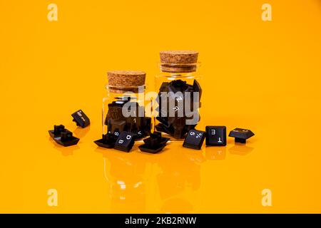 bouton de clavier dans le verre dans le pot dans le seau sur fond orange hacker isolé Banque D'Images