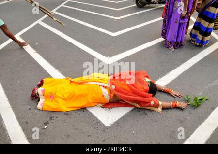 Femme indienne couché prostrate adorant le Dieu du Soleil pendant la puja de Chhat sur une route à Kolkata avant d'aller à la rivière Hooghly. Chhath est un ancien festival hindou et seul festival védique dédié au Dieu du Soleil hindou, Surya et Chathi Maiya sur 13 novembre 2018 dans la ville de Kolkata, Inde. (Photo de Debajyoti Chakraborty/NurPhoto) Banque D'Images