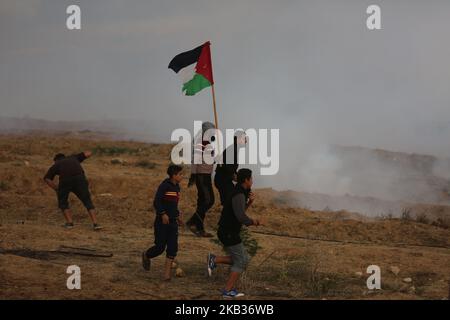 Les manifestants palestiniens portent des drapeaux nationaux lorsqu'ils se rassemblent lors d'une manifestation, à l'est de la ville de Gaza, près de la frontière israélienne sur 16 novembre 2018. - Le cessez-le-feu de Gaza, qui a mis fin à la pire flambée entre Israël et les dirigeants islamistes du territoire, le Hamas, depuis la guerre de 2014, est confronté à son premier test majeur sur l'16 novembre alors que les manifestants palestiniens devraient se rassembler le long de la frontière pour des manifestations de masse qui ont déclenché des violences mortelles les semaines précédentes. (Photo de Majdi Fathi/NurPhoto) Banque D'Images