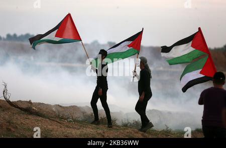 Les manifestants palestiniens portent des drapeaux nationaux lorsqu'ils se rassemblent lors d'une manifestation, à l'est de la ville de Gaza, près de la frontière israélienne sur 16 novembre 2018. - Le cessez-le-feu de Gaza, qui a mis fin à la pire flambée entre Israël et les dirigeants islamistes du territoire, le Hamas, depuis la guerre de 2014, est confronté à son premier test majeur sur l'16 novembre alors que les manifestants palestiniens devraient se rassembler le long de la frontière pour des manifestations de masse qui ont déclenché des violences mortelles les semaines précédentes. (Photo de Majdi Fathi/NurPhoto) Banque D'Images