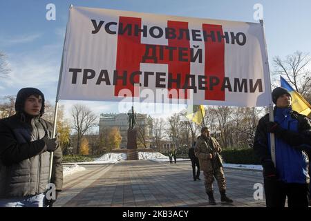 Les opposants à un rassemblement transgenre tiennent une bannière 'No pour l'adoption d'enfants par les personnes transgenres' lors de leur manifestation dans le centre-ville de Kiev, Ukraine, 18 novembre 2018. Deux participants au rassemblement pour le soutien des droits transgenres ont été attaqués par des pulvérisations de poivre alors que la marche pour les droits transgenres a été interrompue par des dizaines de militants des droits de l'extrême. Quelques dizaines de personnes transgenres essayaient d'organiser la marche pour soutenir les droits transgenres et pour honorer la mémoire de ceux qui sont morts à cause de transphobie, de haine et de préjugés et pour marquer la Journée internationale des personnes transgenres. (Photo par S Banque D'Images