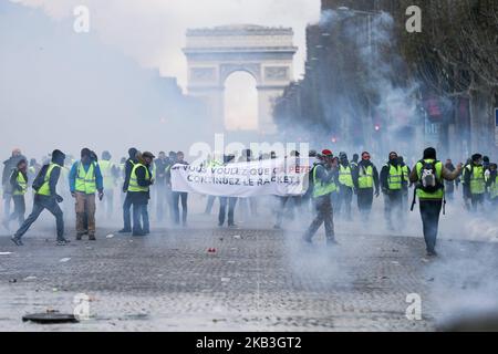 Des manifestants se tiennent devant la police anti-émeute lors d'une manifestation contre les gilets jaunes (Gilets jaunes) contre la hausse des prix du pétrole et des coûts de la vie près de l'Arc de Triomphe sur les champs-Elysées à Paris, sur 24 novembre 2018. Les forces de sécurité à Paris ont tiré du gaz lacrymogène et du canon à eau sur 24 novembre pour disperser les manifestants. Plusieurs milliers de manifestants, portant des vestes jaunes à haute visibilité, se sont rassemblés sur l'avenue dans le cadre des manifestations qui ont commencé sur 17 novembre 2018. (Photo de Michel Stoupak/NurPhoto) Banque D'Images