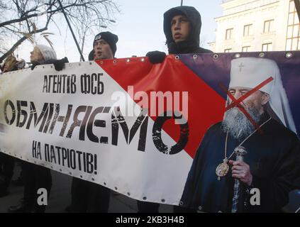 Les nationalistes ukrainiens tiennent une bannière avec des portraits représentant le Métropolite Onufrite, chef de l'Église orthodoxe ukrainienne du Patriarcat de Moscou, lors d'une manifestation contre l'Église orthodoxe ukrainienne du Patriarcat de Moscou en Ukraine près de l'Administration présidentielle à Kiev, en Ukraine, au 24 novembre 2018. (Photo par STR/NurPhoto) Banque D'Images