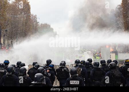 Paris, France, 24 novembre 2018. Les forces de police tentent de contenir les manifestants lors d'une manifestation contre les gilets jaunes (Gilets jaunes) contre la hausse des prix du pétrole et des coûts de la vie près de l'Arc de Triomphe sur les champs-Élysées. Les forces de sécurité à Paris ont tiré du gaz lacrymogène et du canon à eau pour disperser les manifestants. (Photo par Emeric Fohlen/NurPhoto) Banque D'Images