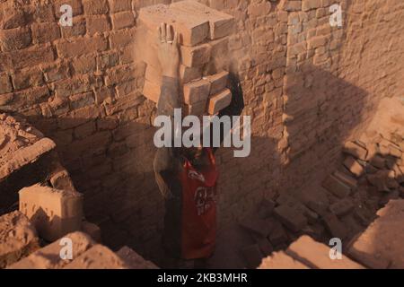 Les lameurs bangladaises travaillent dans un champ de briques à Dhaka, au Bangladesh, sur 28 novembre 2018. Les labeurs travaillent aux champs de briques jusqu'au crépuscule avec une condition malsaine car leur salaire ne répond pas à la norme minimale. (Photo de Rehman Asad/NurPhoto) Banque D'Images