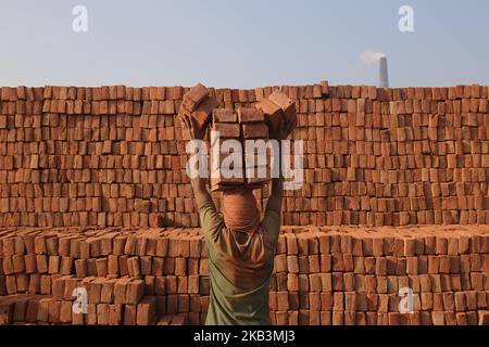 Un travail bangladais travaille dans un champ de briques à Dhaka, au Bangladesh, sur 28 novembre 2018. Les labeurs travaillent aux champs de briques jusqu'au crépuscule avec une condition malsaine car leur salaire ne répond pas à la norme minimale. (Photo de Rehman Asad/NurPhoto) Banque D'Images