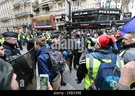 Les manifestants portant un gilet jaune (gilet jaune) font face à des policiers anti-émeute alors qu'ils manifestent contre la hausse des coûts de la vie devant l'Arc de Triomphe à Paris, en France, sur 8 décembre 2018. Paris était en état d'alerte sur 8 décembre, avec des mesures de sécurité importantes en place avant les nouvelles manifestations de la « veste jaune » que les autorités craignaient de ne pas avoir à se retourner contre la violence pour un deuxième week-end consécutif. (Photo de Michel Stoupak/NurPhoto) Banque D'Images