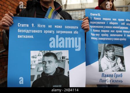 Un ukrainien est muni d'une affiche avec un portrait de Bogdan Nebylitsa (L), marin de la marine ukrainienne qui a été saisi par la Russie lors de l'incident du détroit de Kerch le 25 novembre, lors d'un rassemblement pour soutenir le directeur ukrainien Oleg Sentensov et les prisonniers politiques ukrainiens qui ont emprisonné en Russie. Près de l'ambassade de l'Union européenne à Kiev, Ukraine, 11 décembre 2018. Le Parlement européen a décerné au directeur ukrainien Oleg Sentsov le prix de la liberté de pensée nommé d'après Andrei Sakharov, qui sera remis cette semaine à sa sœur et avocat au Parlement européen. Un tribunal russe a condamné Oleg Sentso Banque D'Images