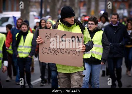 L'étiquette indique « Macron Get Out! ». Après le début de la manifestation pacifique de milliers de 'Jackets jaunes' en 5th (Acte V), la manifestation s'est transformée en escarmouches. La police anti-émeute et la gendarmerie Mobile ont lancé des vols de canisters à gaz lacrymogènes et tiré des balles de balle dans la foule. La police a également utilisé un canon à eau. Le mouvement des vestes jaunes a commencé sur 17 novembre par une protestation contre la hausse des taxes sur les produits pétroliers. Ils ont dit que la hausse des taxes sur les produits pétroliers était le détonateur de leur colère contre le président français Macron et son gouvernement et leur demande de démission Banque D'Images