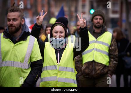 Une veste jaune fait le V-sign. Après le début de la manifestation pacifique de milliers de 'Jackets jaunes' en 5th (Acte V), la manifestation s'est transformée en escarmouches. La police anti-émeute et la gendarmerie Mobile ont lancé des vols de canisters à gaz lacrymogènes et tiré des balles de balle dans la foule. La police a également utilisé un canon à eau. Le mouvement des vestes jaunes a commencé sur 17 novembre par une protestation contre la hausse des taxes sur les produits pétroliers. Ils ont déclaré que la hausse des taxes sur les produits pétroliers était le détonateur de leur colère contre le président français Macron et son gouvernement et leur demande de démission Banque D'Images