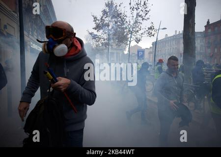 Les manifestants s'éloignent des gaz lacrymogènes. Après le début de la manifestation pacifique de milliers de 'Jackets jaunes' en 5th (Acte V), la manifestation s'est transformée en escarmouches. La police anti-émeute et la gendarmerie Mobile ont lancé des vols de canisters à gaz lacrymogènes et tiré des balles de balle dans la foule. La police a également utilisé un canon à eau. Le mouvement des vestes jaunes a commencé sur 17 novembre par une protestation contre la hausse des taxes sur les produits pétroliers. Ils ont déclaré que la hausse des taxes sur les produits pétroliers était le détonateur de leur colère contre le président français Macron et son gouvernement et leur demande de démission Banque D'Images