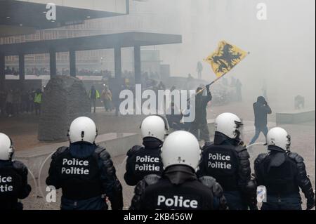 16 décembre 2018, à Bruxelles, Belgique. Un certain nombre d'associations belges de droite ont participé à la rencontre "la révolte contre Marrakech" à Bruxelles pour protester contre un pacte de l'ONU sur les migrations, qui a été adopté lors d'une conférence internationale à Marrakech. Selon la police, environ 5 500 personnes se sont rassemblées dimanche à Bruxelles pour protester contre le pacte de l'ONU sur les migrations. La police a déployé des gaz à effet de téargas et des canons à eau après que des éraflures ont éclaté. Des partisans d'extrême droite lancent des barricades et détruisent plusieurs propierties autour du bâtiment européen de l'Union à Schuman. La police est intervenue pour disperser la foule après des projectiles Banque D'Images