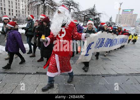 Des jeunes de différents services sociaux ukrainiens vêtus de costumes du Père Noël participent à la parade des assistants de Saint-Nicolas, au centre de Kiev, lors de la célébration de la Saint-Nicolas, à Kiev, en Ukraine, le 19 décembre 2018. Les bénévoles portant les costumes des assistants de Saint-Nicolas donnant des cadeaux aux enfants dans les orphelinats, les hôpitaux et les enfants des familles pauvres. Les Ukrainiens marquant le jour de Saint Nicolas sur 19 décembre. (Photo de NurPhoto) Banque D'Images