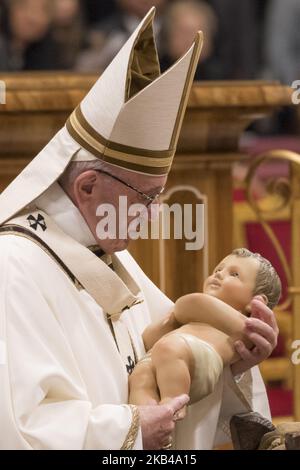Le pape François tient une statue de bébé Jésus comme il part à la fin de la messe de la veille de Noël dans la basilique Saint-Pierre au Vatican, le lundi 24 décembre 2018. (Photo de Massimo Valicchia/NurPhoto) Banque D'Images