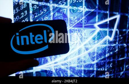 Le logo d'Intel est visible sur un écran de smartphone à côté d'un écran avec une illustration de la bourse. Intel est répertorié dans Nasdaq. Le Nasdaq est la deuxième plus grande bourse au monde après la Bourse de New York. (Photo par Alexander Pohl/NurPhoto) Banque D'Images