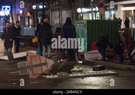 Un groupe de personnes assis à une table devant un bâtiment en place Pierre Mendes dommages après l'Acte 10 des gilets jaunes (gilets jaunes) démontrés à Angers, France, le 19 janvier 2019. Des affrontements ont eu lieu en place Pierre Mendes France, juste en face de l’Hôtel de ville.une fois que les derniers manifestants ont dispersé autour de 18 h 30, la région ressemblait à un champ de bataille, Les manifestants ayant bénéficié de la présence de matériaux pour la construction de la ligne B du tramway pour construire des barricades.le soir, la police, les pompiers et les autorités municipales ont tenté de sécuriser la zone. (Photo par Estelle Ruiz/N. Banque D'Images