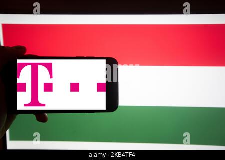 Le logo de Magyar Telekom Nyrt. (' Hongrois Telekom PLC. '; nom légal complet: Magyar Telekom Távközlési Nyilvánosan M?köd? Részvénytársaság, ' Magyar Telekom Telecommunications public Limited Company ') est vu sur un écran de smartphone devant un drapeau hongrois. Il fait partie du BUX, l'indice majeur de la Hongrie. Elle est une filiale de Deutsche Telekom (59,21% des actions). (Photo par Alexander Pohl/NurPhoto) Banque D'Images