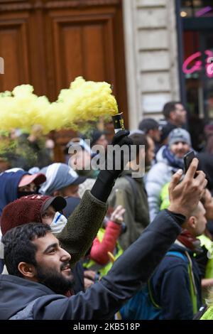 Comme un manifestant de Vest jaune tient une fumée jaune, un autre prend un selfie. Pour l'Acte XI du mouvement de la Vest jaune, plus de 10 000 personnes sont descendues dans les rues de Toulouse pour la manifestation antigouvernementale. Des accrochages ont eu lieu entre les manifestants et la police anti-émeute pendant 3 heures. La police anti-émeute a utilisé une cartouche de gaz lacrymogène et un canon à eau de police. Le mouvement des jaquettes jaunes a commencé sur 17 novembre par une protestation contre la hausse des taxes sur les produits pétroliers. La hausse des impôts a été le détonateur de leur colère contre le président français Macron et son gouvernement et de leur demande de démission.Toulous Banque D'Images