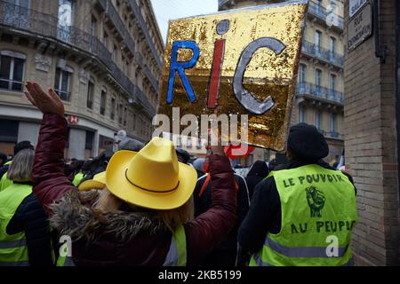 Un proester de la Vest jaune déguisé en vache-fille tient un écriteau appelant le RIC (référendum initié par les citoyens). Pour l'Acte XI du mouvement de la Vest jaune, plus de 10 000 personnes sont descendues dans les rues de Toulouse pour la manifestation antigouvernementale. Des accrochages ont eu lieu entre les manifestants et la police anti-émeute pendant 3 heures. La police anti-émeute a utilisé une cartouche de gaz lacrymogène et un canon à eau de police. Le mouvement des jaquettes jaunes a commencé sur 17 novembre par une protestation contre la hausse des taxes sur les produits pétroliers. La hausse des impôts a été le détonateur de leur colère contre le président français Macron et son gouvernement an Banque D'Images