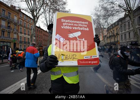 Un manifestant Yellow Vest essaie de se cacher derrière un signe. Pour l'Acte XI du mouvement de la Vest jaune, plus de 10 000 personnes sont descendues dans les rues de Toulouse pour la manifestation antigouvernementale. Des accrochages ont eu lieu entre les manifestants et la police anti-émeute pendant 3 heures. La police anti-émeute a utilisé une cartouche de gaz lacrymogène et un canon à eau de police. Le mouvement des jaquettes jaunes a commencé sur 17 novembre par une protestation contre la hausse des taxes sur les produits pétroliers. La hausse des impôts a été le détonateur de leur colère contre le président français Macron et son gouvernement et leur demande de démission.Toulouse. France. Janv Banque D'Images