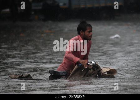 Un homme pousse un vélo alors qu'il se déplace dans une rue inondée lors de fortes pluies à Mumbai, Inde, le 04 septembre 2019. La mousson en Inde dure officiellement de juin à septembre. (Photo par Himanshu Bhatt/NurPhoto) Banque D'Images