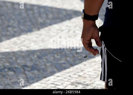 Un fumeur tient une cigarette à Lisbonne, au Portugal, sur 4 septembre 2019. La loi approuvant les mesures pour la collecte et le traitement des déchets de tabac et punit avec des amendes entre 25 et 250 euros ceux qui jettent des boires sur la voie publique a été publiée sur le Journal de 3 septembre en République. Les mégots de cigarettes, les cigares ou autres cigarettes contenant des produits du tabac seront assimilés, à partir d'aujourd'hui, aux déchets urbains solides, et leur élimination dans l'espace public est donc interdite. (Photo par Pedro Fiúza/NurPhoto) Banque D'Images