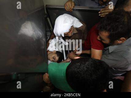 [NOTE DE LA RÉDACTION: L'image dépeint le contenu graphique] des parents d'Ali Al Ashqar, un palestinien de 17 ans, qui a été tué lors d'affrontements à la suite d'une manifestation à la clôture frontalière entre Israël et Gaza, pleurent par son corps à la morgue de l'hôpital de Beit Lahya, dans la bande de Gaza, sur 6 septembre 2019. (Photo de Majdi Fathi/NurPhoto) Banque D'Images
