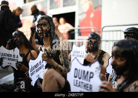 Les manifestants du PETA manifestent à l'extérieur du site principal de la semaine de la mode de Londres, se couvrant de colle noire, pour protester contre l'utilisation du cuir et de la fourrure dans l'industrie de la mode, Londres, sur 13 septembre 2019. (Photo par Alberto Pezzali/NurPhoto) Banque D'Images