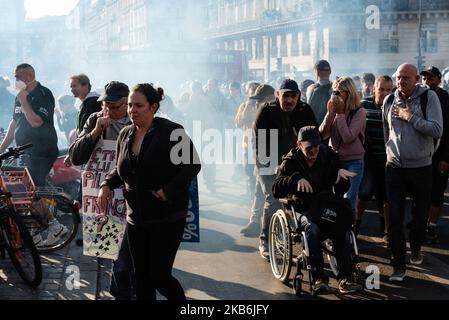 Des manifestants, y compris un homme handicapé en fauteuil roulant, fuient le gaz lacrymogène de la police pour disperser une tentative de manifestation sur l'esplanade de la gare Saint-Lazare samedi, 21 septembre 2019, pour l'acte 45 des Gilets Jaunes, Qui a organisé une grande journée de mobilisation nationale à Paris dans le but de récupérer les champs-Elysées. Après avoir essayé en vain toute la matinée de se réunir dans le centre de Paris, chaque fois dispersés par la police, les Vêtes jaunes et le Bloc noir se sont joints à la marche pour le climat organisée par les organisations environnementales. Rapidement, des affrontements entre le Bloc noir et la police b Banque D'Images