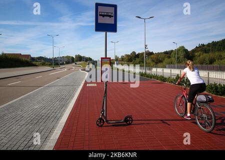 Une femme à vélo et un kick-scooter à un arrêt de bus sont vus à Gdansk, Pologne, le 22 septembre 2019 pendant le jour sans voiture chaque personne avec un document d'enregistrement valide de la voiture pourrait monter dans un transport public (bus, tram ou train) sans billet, totalement gratuit. Pendant la semaine de 22 septembre, la marche, le vélo, les transports en commun et le covoiturage sont les moyens de promouvoir les transports en commun. Les transports publics contribuent à économiser l'énergie et à réduire les émissions, car le nombre de véhicules a été réduit. (Photo de Michal Fludra/NurPhoto) Banque D'Images