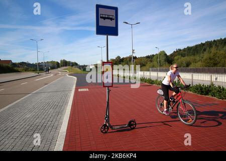 Une femme à vélo et un kick-scooter à un arrêt de bus sont vus à Gdansk, Pologne, le 22 septembre 2019 pendant le jour sans voiture chaque personne avec un document d'enregistrement valide de la voiture pourrait monter dans un transport public (bus, tram ou train) sans billet, totalement gratuit. Pendant la semaine de 22 septembre, la marche, le vélo, les transports en commun et le covoiturage sont les moyens de promouvoir les transports en commun. Les transports publics contribuent à économiser l'énergie et à réduire les émissions, car le nombre de véhicules a été réduit. (Photo de Michal Fludra/NurPhoto) Banque D'Images