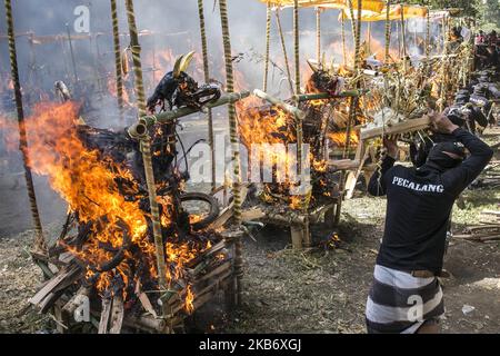 Cercueil en forme de dragon et de taureau mythiques brûlé lors de la crémation de masse ou de rituels locaux appelés Ngaben dans la cour du village de Bayad à Tegallalang, Gianyar, Bali sur 25 septembre 2019. Un total de 59 corps, sous la forme de squelettes humains qui sont morts il y a plusieurs années, ont été incinérés simultanément afin de faciliter le coût de la cérémonie pour les résidents locaux. (Photo de Johannes Christo/NurPhoto) Banque D'Images