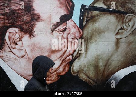 Les femmes passent par le graffiti de Dmitri Vrubel intitulé « mon Dieu, aidez-moi à survivre à cet Amour mortel » , montrant Leonid Brejnev et Erich Honecker dans l'étreinte fraternelle. Painting est situé à la East Side Gallery à Berlin, en Allemagne, le 25 septembre 2019. (Photo de Jakub Porzycki/NurPhoto) Banque D'Images