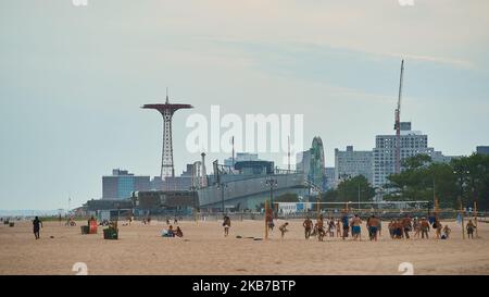 Les personnes jouant au volley-ball sur la plage de Coney Island lors d'une soirée à ciel ouvert Banque D'Images