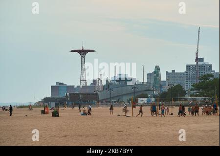 Les personnes jouant au volley-ball sur la plage de Coney Island lors d'une soirée à ciel ouvert Banque D'Images