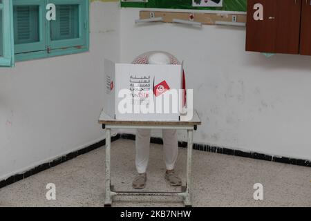 Une Tunisienne âgée plonge son doigt dans l'encre juste avant de voter aux élections législatives dans un bureau de vote de la ville d'Ennasr, dans le gouvernorat d'Ariana, au nord-est de la capitale Tunis, sur 6 octobre 2019. (Photo de Chedly Ben Ibrahim/NurPhoto) Banque D'Images