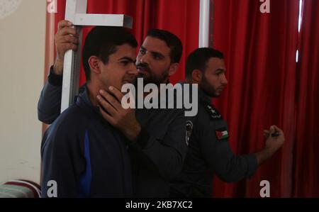 Un palestinien subit un examen de condition physique par un membre du mouvement islamiste, la sécurité du Hamas, dans un centre de formation de la police de la ville de Gaza, à 8 octobre 2019, pour avoir une chance de postuler à un emploi de police. (Photo de Majdi Fathi/NurPhoto) Banque D'Images