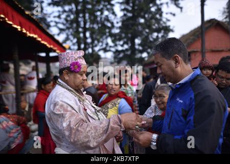 Un prêtre népalais offrant une fleur sainte pendant la dixième journée du festival Dashain Durga Puja au temple de Bramayani, Bhaktapur, Népal, mardi, 08 octobre 2019. Dashain est le festival le plus populaire et le plus célébré au Népal, qui reflète les traditions ancestrales et la dévotion des Népalais envers la déesse Durga. (Photo de Narayan Maharajan/NurPhoto) Banque D'Images